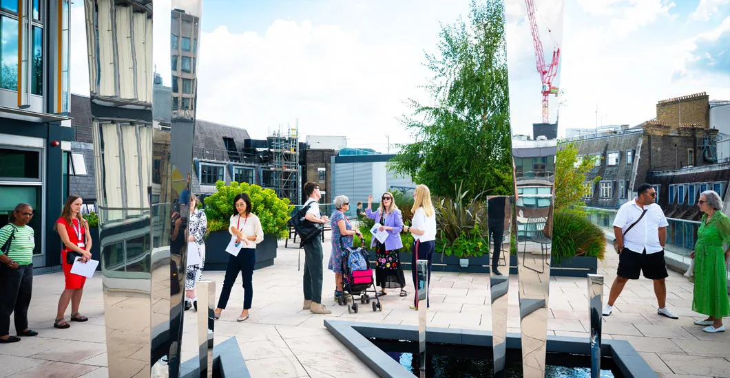 Regular Giving supporters mingle with LSE staff as they explore the Chorus of Ripples sculpture